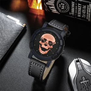 Detailed close-up of a black skull watch with rose gold dial and leather strap