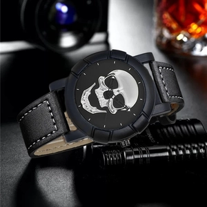 Close-up of hip-hop watch featuring a skull dial and black leather strap with white stitching