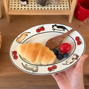 Gros plan d'une assiette ovale en céramique avec motifs de chats et tomates mignons