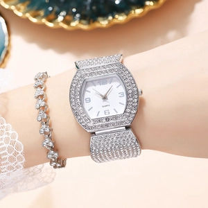 Close-up of luxury women's silver tonneau watch and heart bracelet with rhinestones