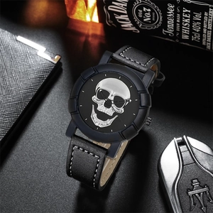 Detail of hip-hop watch with silver skull dial next to premium leather wallet and car key