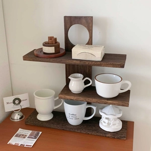 Detailed close-up of a 3-tier dark walnut wood display shelf with a coffee cup and decor