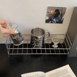 Detail of a minimalist stainless steel wire rack used for stylish desktop organization
