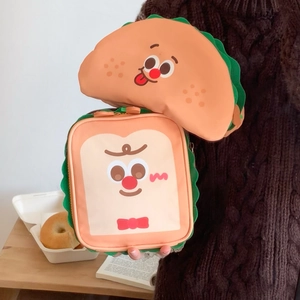 Cute toast and taco shaped makeup bags with cartoon faces on a warm wooden background