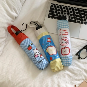 Compact folding umbrella with cartoon pattern and matching pouch on a desk with laptop