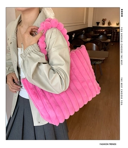 Détail du sac cabas rose vif en fausse fourrure avec texture et anse à pompons