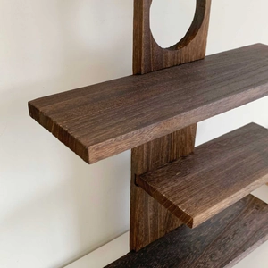 Detail of vintage dark wood display shelf showing grain texture and sturdy structure
