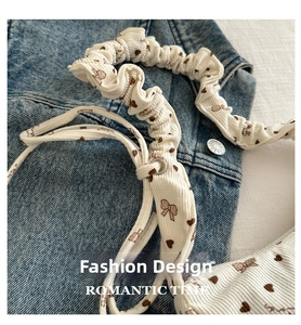 Detail of cream corduroy fabric with brown bow prints and metallic silver eyelets
