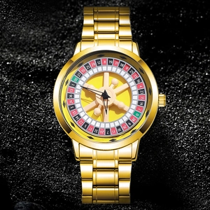 Macro shot of gold roulette wheel watch face with numeric red and black scales and metal strap
