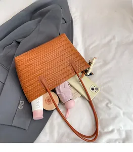 Macro view of the brown woven tote bag interior showing spacious storage for daily items
