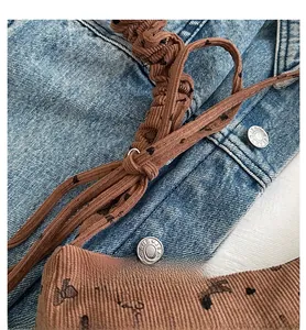 Détail du sac cabas en velours côtelé marron avec motif cœur et cordon sur denim