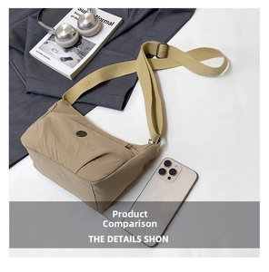 Close-up of khaki nylon crossbody bag showing the metallic logo and zipper detail