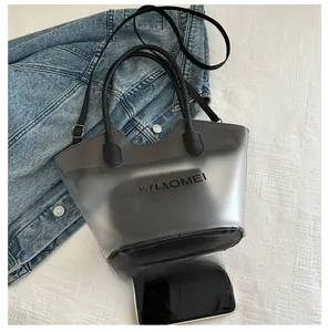 Detail view of large black tote bag with inner pouch and adjustable shoulder strap