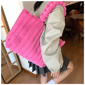 Détail du sac cabas en peluche rose avec rayures verticales et bandoulière à pompons doux