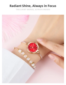 Detail einer schlanken roségoldenen Armbanduhr mit rotem Zifferblatt am Handgelenk