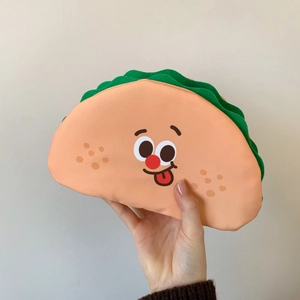 Handheld view of a creative taco-shaped makeup bag with cute cartoon facial expression