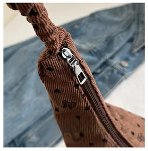 Gros plan d'une fermeture éclair en métal lisse sur un sac hobo en velours côtelé