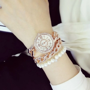 Dettaglio dell'orologio a catena oro rosa e set bracciale di perle con strass luminosi