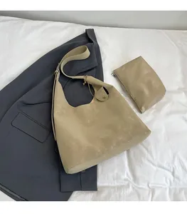 Detail view of khaki faux leather tote bag set including a small pouch on a blazer