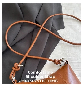 Close-up of brown leather strap with cylindrical design and silver metal clasp