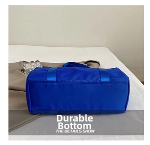 Close-up of durable reinforced nylon bag bottom with webbing straps in navy blue