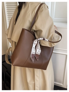 Detail of dark brown tote bag with decorative scarf and elegant vertical stitching