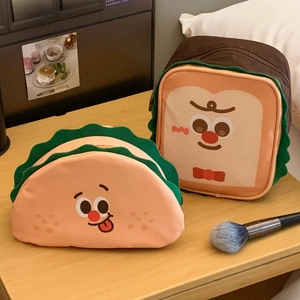 Macro detail of cute toast and taco makeup bags with cartoon faces and lettuce-shaped edges