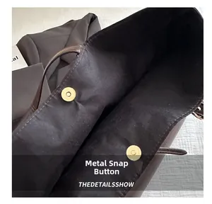 Detailed close-up of the vintage tote bag showing its golden magnetic snap closure