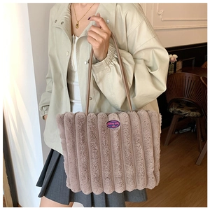 Detail view of pink plush tote bag with vertical stripes and Fashion Girl embroidery