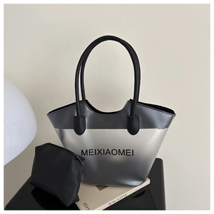 Détail du sac fourre-tout dégradé argent-noir avec pochette assortie sur surface polie