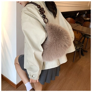 Detail of soft light brown plush dumpling bag with distinctive large wooden bead strap