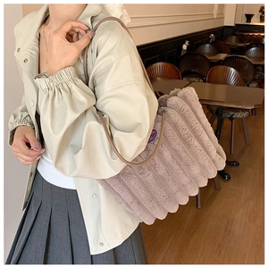 Detail of grey plush quilted tote bag showing soft faux fur texture and slim strap