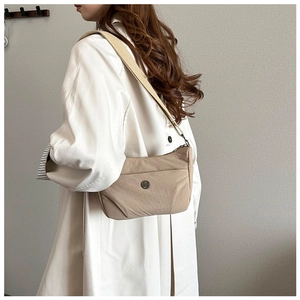 Asian model wearing a khaki nylon half-moon crossbody bag with wide canvas strap