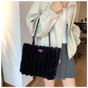 Detail of black faux fur tote bag with vertical stripes and Fashion Girl emblem