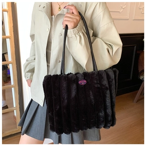 Close-up of black plush tote bag with striped fur texture and a Fashion Girl logo patch