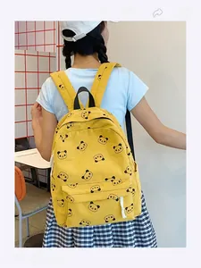 Dettaglio dello zaino in velluto a coste giallo con stampe panda e tasche con zip