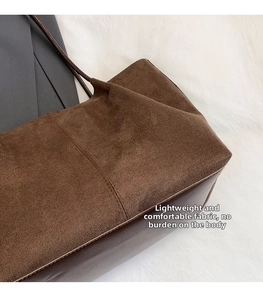 Detail of premium brown suede and smooth leather stitching on a large tote bag