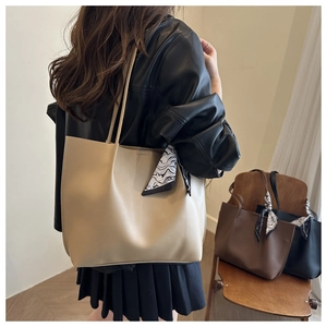 Detail of minimalist cream tote bag with elegant printed silk scarf handle decoration