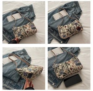 Detail view of floral embroidered canvas underarm bag with silver beaded bow charm accessory