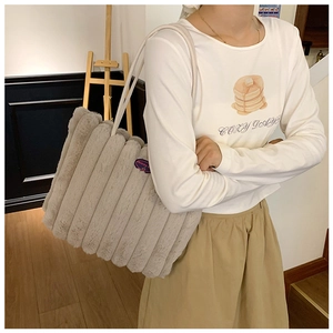 Detail of grey plush tote bag with quilted stripes and soft faux fur texture for women