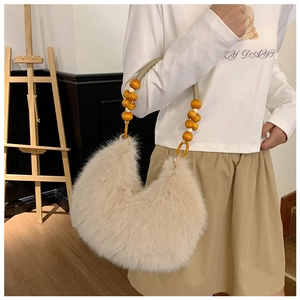 Detail of faux fur shoulder bag with decorative wooden beads and woven strap