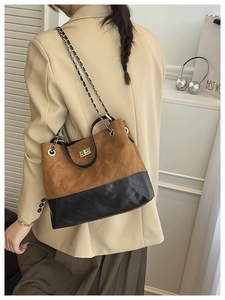 Detail of quilted suede tote bag with chain strap shown on model in khaki blazer
