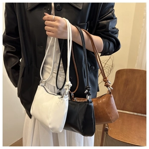 Detail of shoulder bag featuring smooth leather texture and elegant knot strap accents