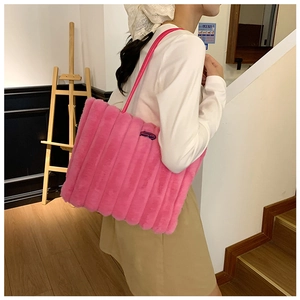 Detail of pink faux fur tote bag with vertical stripes and thin shoulder straps