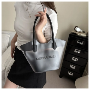 Détail du grand sac cabas gris translucide avec poignées noires porté par un mannequin
