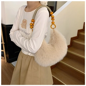 Detail of off-white faux fur hobo bag with wooden beads and woven shoulder strap