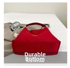 Detail showing the reinforced wear-resistant base of the red canvas tote bag for extra capacity