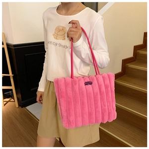 Detail of hot pink fuzzy tote bag showing padded plush texture and slim leather straps
