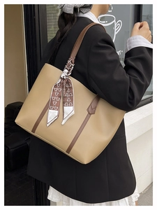 Detail view of beige PU leather tote bag with brown handles and bear print scarf accessory