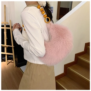 Detail of pink faux fur crescent bag featuring yellow wooden bead shoulder strap